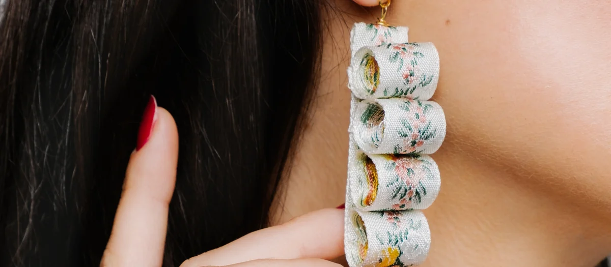 Model wearing a long pearl and crystal drop earring with gold rings, an example of Vidd Studios jewelry work
