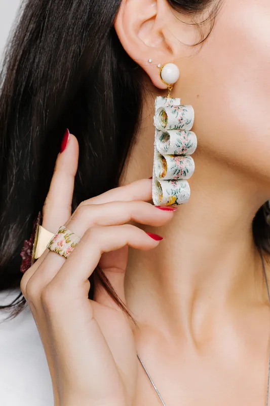 Model wearing a long pearl and crystal drop earring with gold rings